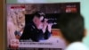Hành khách tại một trạm xe lửa ở Seoul, Nam Triều Tiên, xem tin tức trên màn hình TV cảnh chủ tịch Kim Jong Un của Bắc Hàn đang dùng ống nhòm quan sát, ngày 5/7/2017.